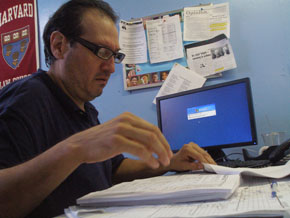 Juan Ramon rios looks through papers at his desk