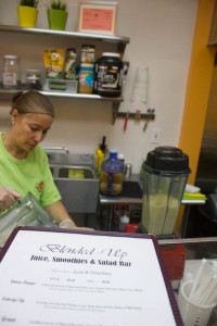 Carmen Arias, an employee at Blended Up juice bar, pours a pineapple smoothie customers coming in for the afternoon rush. 