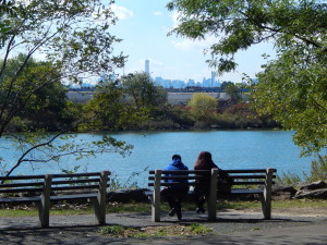 A couple sits by the Bronx River, which runs adjacent to the park's "greenway" (ELIZABETH GOLDBAUM/THE BRONX INK)