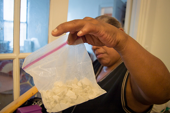 Tenant Denise Baez held up a bag of paint chips from her apartment containing lead.