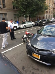 Photo by Mike Elsen-Rooney. Police examine an overturned motorcycle after a crash on Walton Rd. near Yankee Stadium yesterday.