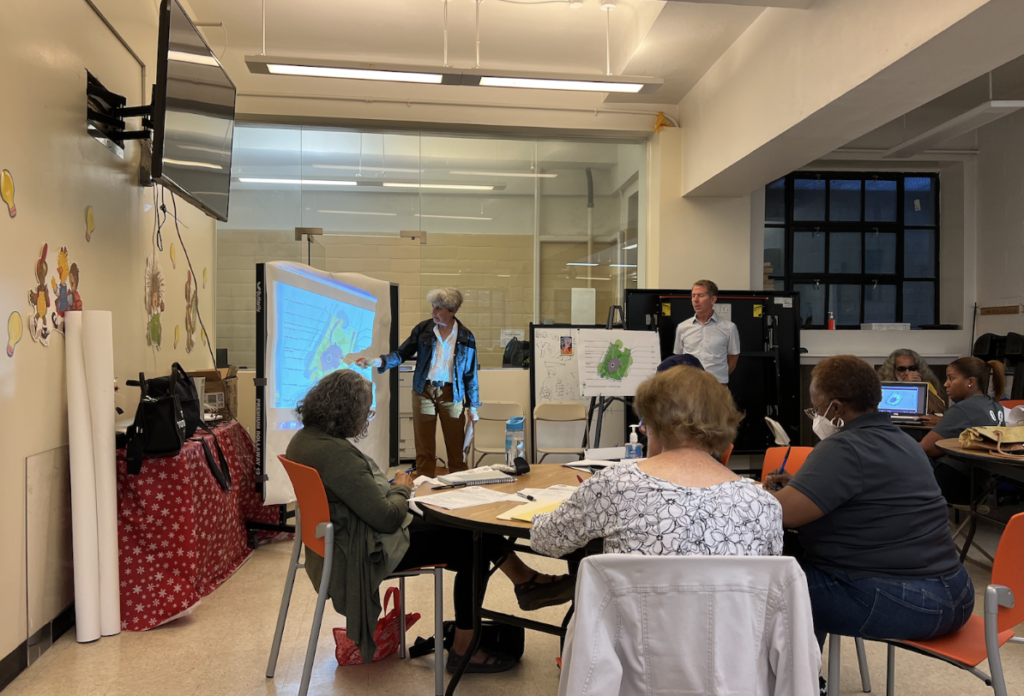 A woman, Marcha Johnson, presents on the Poe Park reconstruction project during Community Board 7’s Parks, Recreation and Cultural Affairs meeting.